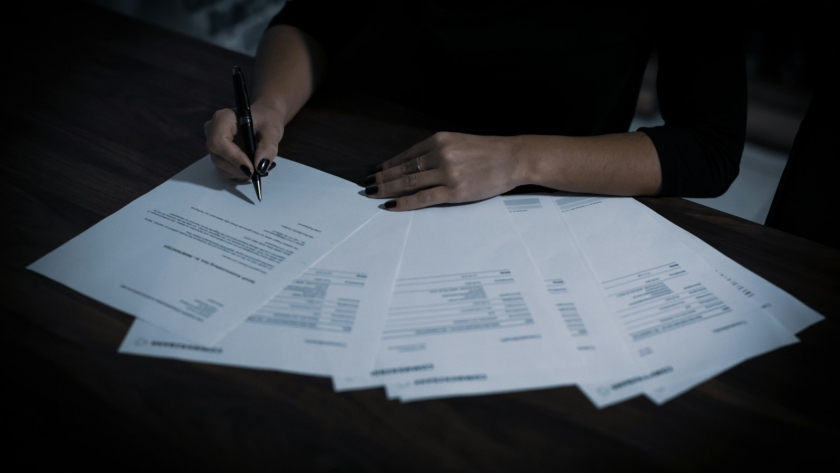 a woman sitting at a table with lots of papers