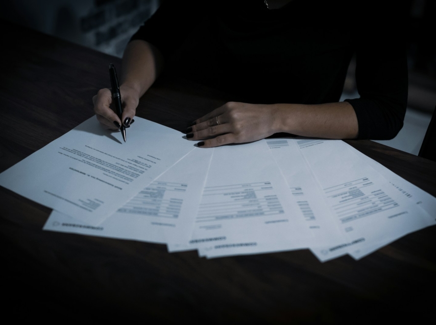 a woman sitting at a table with lots of papers